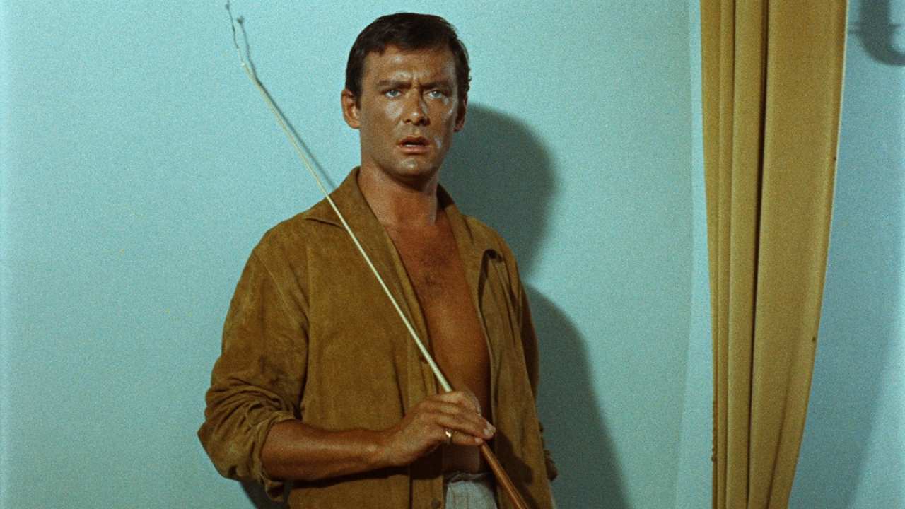a man with an open shirt holding a fishing rod